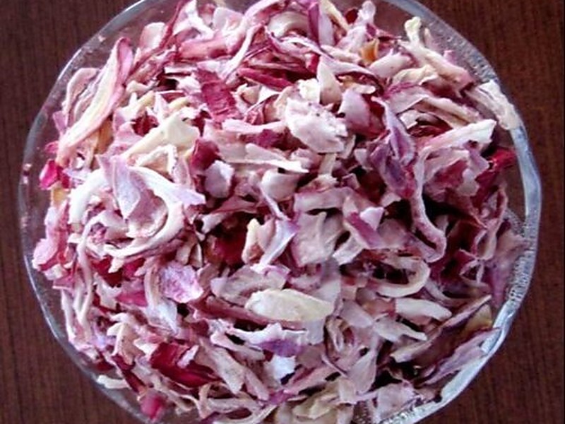 Bowl of pink onion flakes on a wooden table