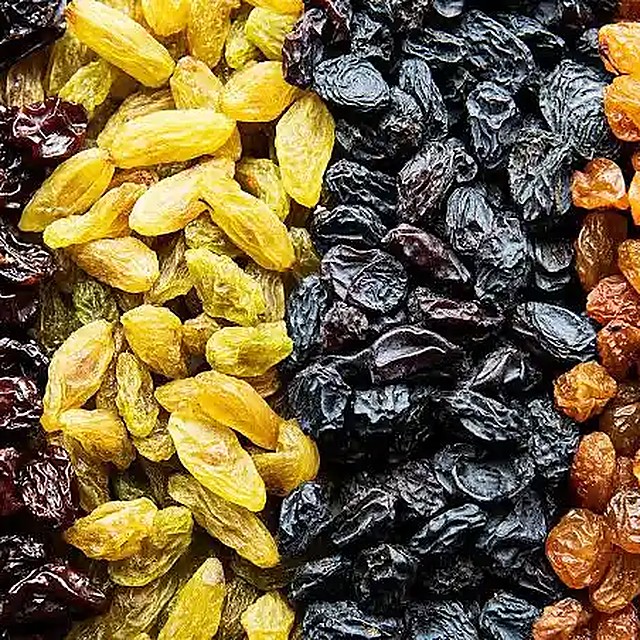 Brown, green, black and golden raisins side by side